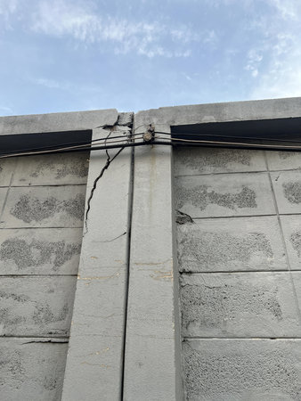 a concrete wall with a broken crack in it.の写真素材