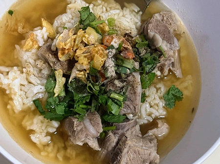 A photography of a bowl of soup with meat