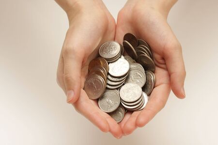 Silver coins in hands on abstract backgroundの写真素材