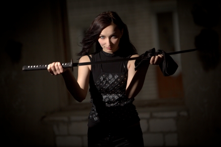 Beautiful woman in leather clothing holding saberの写真素材
