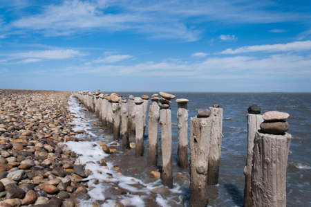 In Provence, near Camargue, France the ocean line is fileld with miles of poles on the ocean coast with stones carefully put on top of each other  A really interesting activity which makes you wonder whoever had tiem to do this の写真素材