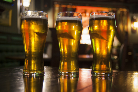 Three Glasses of Beer on a Table in  Pubの写真素材