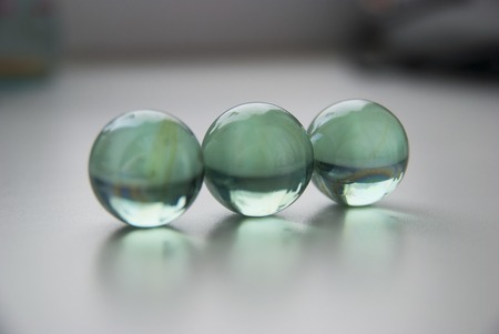 crystal glass balls in line on white grey background surface.の写真素材