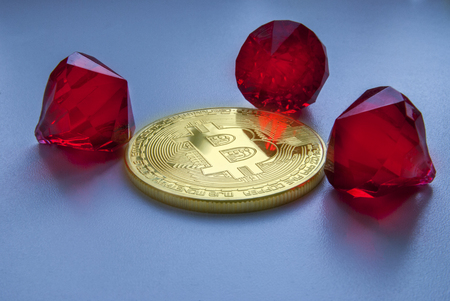Gold Bitcoin on white background with a diamonds. Bitcoin red emeralds treasure.の写真素材