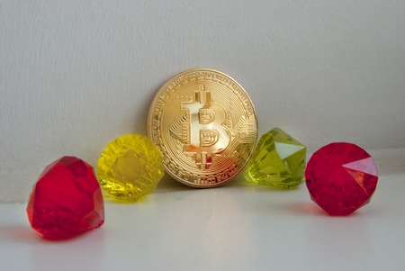 Gold Bitcoin on white background with a diamonds. Bitcoin red emeralds treasure.の写真素材