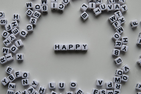 happy word written on cubes on white background. Creative text for your business. Chaotic letters design.の写真素材