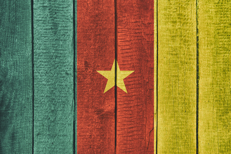 Old  wooden table texture background top view  with a National Flag of Cameroon. Cameroon Flags image.の写真素材