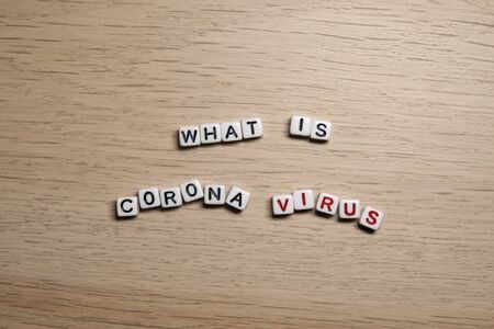 the word WHAT IS CORONA VIRUS in white cubes on a light wooden background. CoronaVirus design template.の写真素材