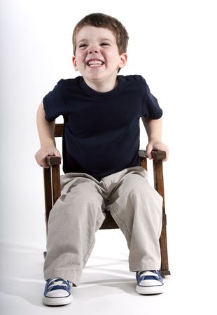 Young preschool age boy sitting in a rocking chair smilingの写真素材