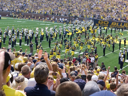 University of Michigan football players run onto the field at the Big House in Ann Arbor, Michigan, during the 2011 season opener against Western Michigan University of Saturday, Sept. 3, 2011.のeditorial素材