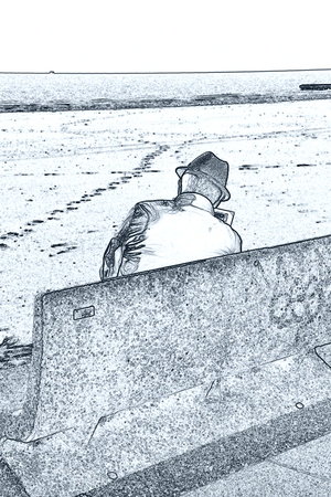 man reding newspaper on bench at beachの写真素材