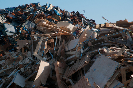 Mountain of garbage consisting of metal and wood with a blue sky in the backgroundの写真素材