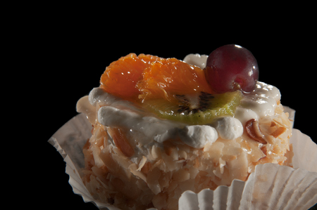 Close-up of a pastry topped with fruit on a black backgroundの写真素材