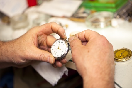 Clockmaker in his workshop repairing