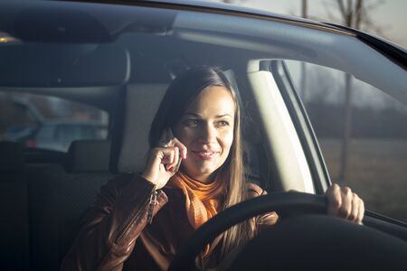 Woman talking on the phone while drivingの写真素材