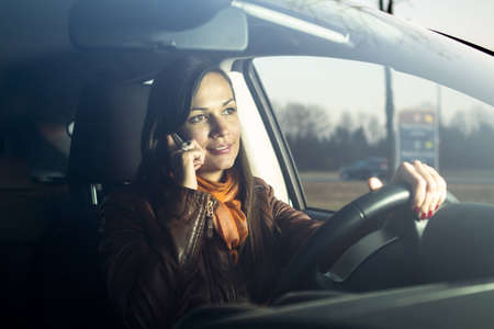 Woman talking on the phone while drivingの写真素材