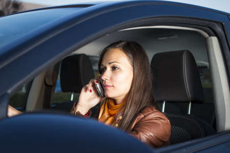 Woman talking on the phone while drivingの写真素材