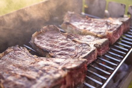Steaks being grilled on the barbecueの写真素材
