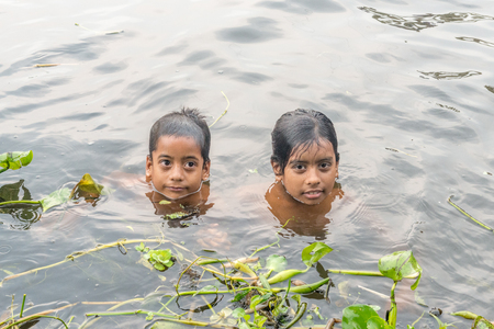 Munshigonj, Bangladesh - July 29, 2016: Children taking bath in a pond to beat the heat of scorching sun, on July 29, 2016 in in the village of Munshogonj, bangladesh.のeditorial素材