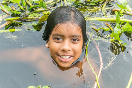 Munshigonj, Bangladesh - July 29, 2016: Children taking bath in a pond to beat the heat of scorching sun, on July 29, 2016 in in the village of Munshogonj, bangladesh.のeditorial素材