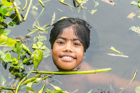 Munshigonj, Bangladesh - July 29, 2016: Children taking bath in a pond to beat the heat of scorching sun, on July 29, 2016 in in the village of Munshogonj, bangladesh.のeditorial素材