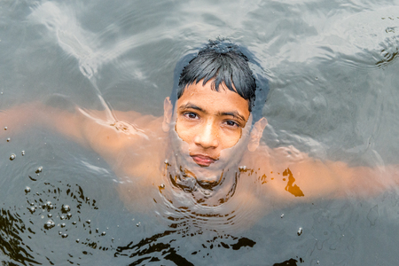 Munshigonj, Bangladesh - July 29, 2016: Children taking bath in a pond to beat the heat of scorching sun, on July 29, 2016 in in the village of Munshogonj, bangladesh.のeditorial素材