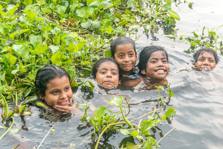 Munshigonj, Bangladesh - July 29, 2016: Children taking bath in a pond to beat the heat of scorching sun, on July 29, 2016 in in the village of Munshogonj, bangladesh.のeditorial素材