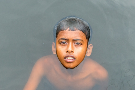 Munshigonj, Bangladesh - July 29, 2016: Children taking bath in a pond to beat the heat of scorching sun, on July 29, 2016 in in the village of Munshogonj, bangladesh.のeditorial素材