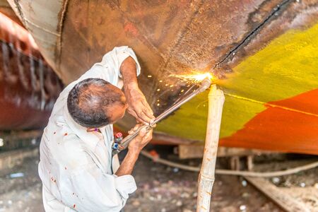 DHAKA, BANGLADESH - August 13: Local workers are working to repair ships in dockyard on August, 13, 2016 in Dhaka, Bangladeshのeditorial素材