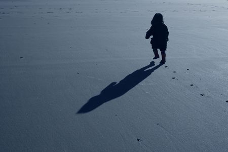 Boy walking on beach with determinationの写真素材