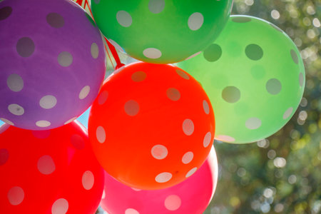 Bright color party balloons with polka dots and Bokeh backgroundの写真素材