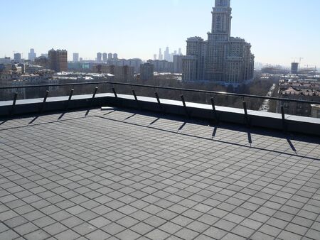 a rooftop balcony with a cityscape background.の写真素材