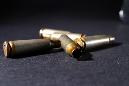 Empty bullet shell casings, on a black background, smoke.の写真素材