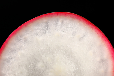 A slice of radish on a black background.の写真素材