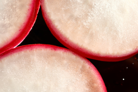 A slice of radish on a black background.の写真素材