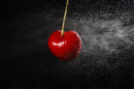 Cherries with water drops on black background.