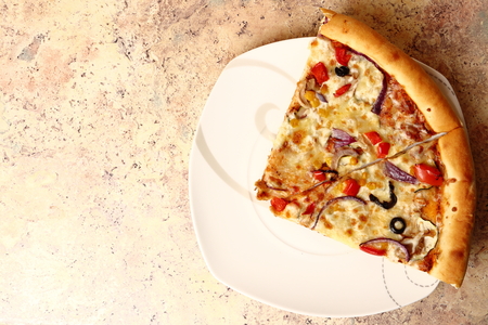 pizza with melted mozzarella cheese and vegetables on a thin crustの写真素材