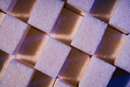 A composition of sugar cubes illuminated with multicolored light sources.の写真素材