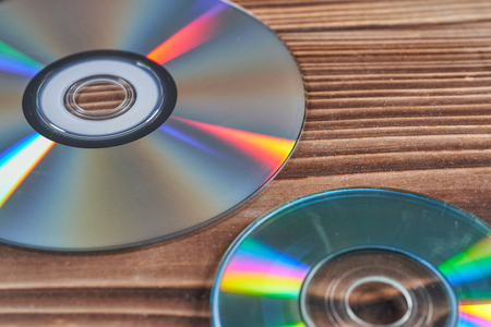 Laser discs are on a wooden table.