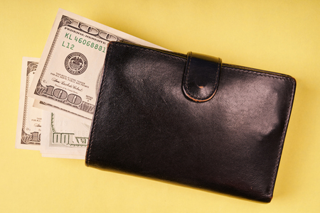 Leather wallet with us dollars on colored paper background.の写真素材