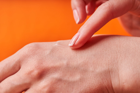 Beautiful manicured girl hands with moisturizing cream.の写真素材