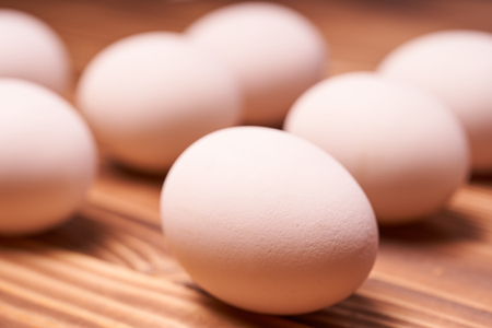 Chicken eggs laid on a wooden table.の写真素材