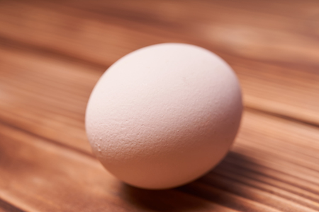 Chicken eggs laid on a wooden table.