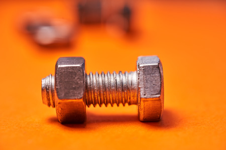 Bolted connecting elements on orange background close-up.の写真素材
