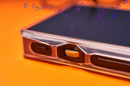 Portable music player on orange background close-up.の写真素材