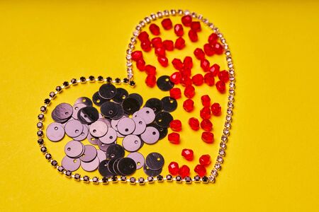 Embroidery products and tools. Heart, rhinestone, sequin and red roundels on a yellow background.の写真素材