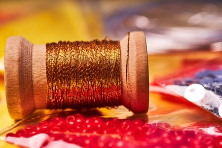 Embroidery products and tools. The spool of metallic thread, Japanese seed beads and sequins on a...