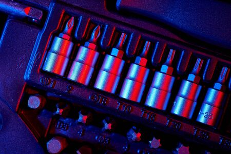 Screwdriver bits in the repair tool kit. Mixed lighting.