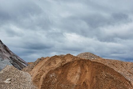 Industrial quarry with mountains of sand and rubble.