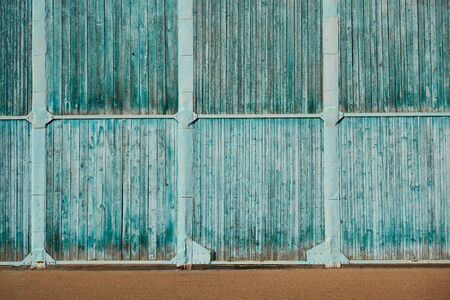 The wall of the old hangar of wooden panels on a metal frame.